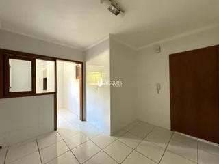 Vista de um corredor interno com piso de cerâmica branca e portas de madeira.