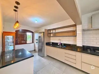 Vista da cozinha com armários e bancadas escuras.