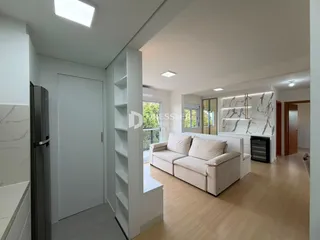 Sala de estar com sofá e estantes em um apartamento em Lajeado.