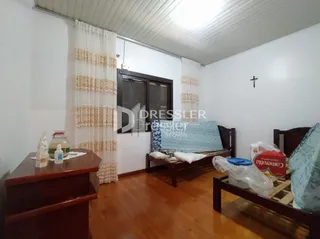Sala de estar com piso de madeira e cortinas claras.