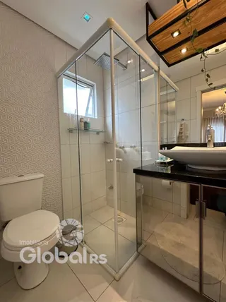 Banheiro moderno com box de vidro e piso de cerâmica.