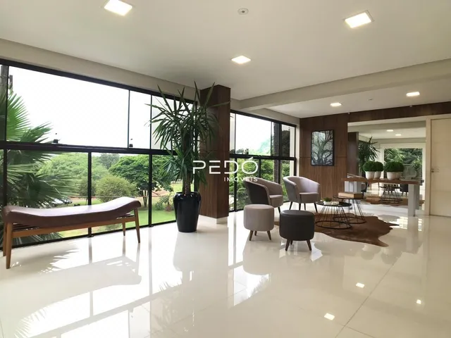 Sala de estar moderna com grandes janelas e vista para o exterior.