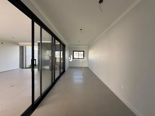 Um interior amplo com portas de vidro se estende por uma longa área.
