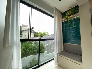 Sala de estar com vista para o exterior através de grandes janelas.