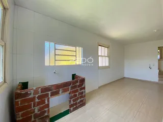 Vista de um ambiente interno com parede de tijolos aparentes e piso de cerâmica.