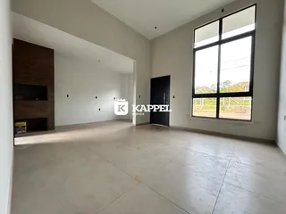 Sala ampla com piso claro e grande janela.