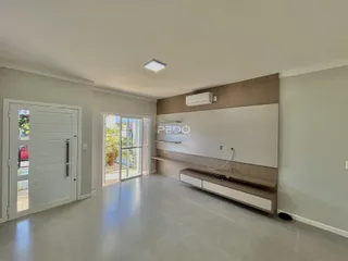 Sala de estar com piso claro e portas de vidro que dão acesso ao exterior.