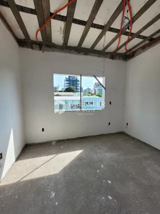 Foto da estrutura interna de um ambiente com teto exposto.