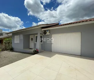 Fachada de uma residência em Lajeado, Brasil, com garagem e área externa pavimentada.