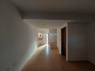 Corredor interno de uma residência com piso de madeira clara.
