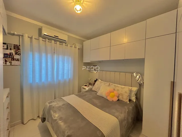 Quarto com cama e armários brancos em um imóvel no Brasil.