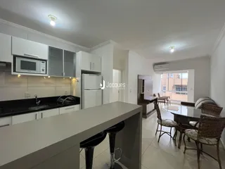 Ambiente de cozinha e jantar moderno com ilha e sala de estar em Lajeado.