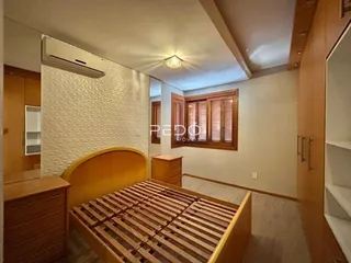 Quarto com cama de madeira e ar-condicionado instalado.