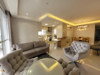 Sala de estar moderna com sofás e poltronas em um apartamento.