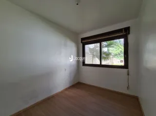 Parede interna com piso de madeira e janela de madeira.