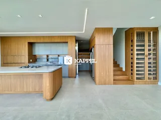 Cozinha moderna com ilha central e armários de madeira em um imóvel em Lajeado.
