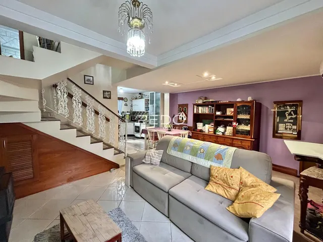 Sala de estar com escadaria e piso de madeira em uma propriedade.