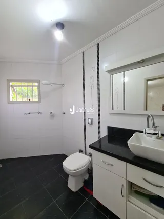 Foto de um banheiro moderno com piso escuro e revestimento branco.