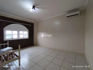 Quarto com janela e parede de tijolos aparentes.