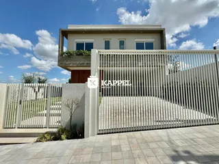 Foto da fachada de uma casa moderna com cerca branca em Lajeado, Brasil.