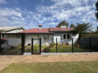 Fachada de uma casa em Lajeado, Brasil, com cerca e jardim na frente.