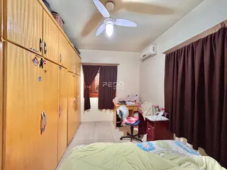 Quarto com armários de madeira e cama no interior de uma residência.