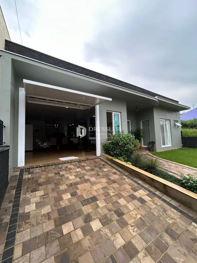 Vista da fachada de uma residência em Lajeado, Brasil, mostrando a área coberta e o pátio externo.