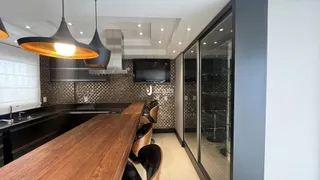 Cozinha moderna com ilha de madeira e portas de vidro.