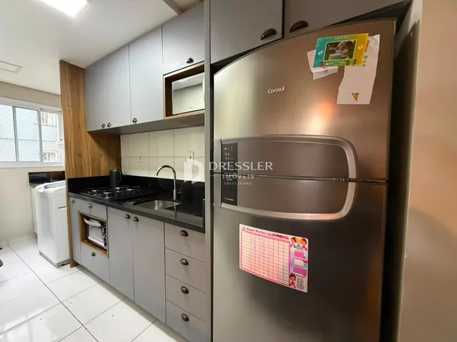 Foto de uma cozinha com armários cinzas e piso branco.