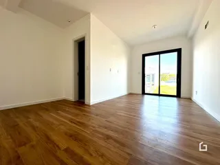 Ambiente interno com piso de madeira e paredes brancas.