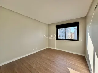 Ambiente interno com piso de madeira e janela de vista para o exterior.