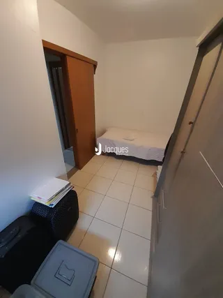 Quarto com piso de cerâmica e cama visível na sala.