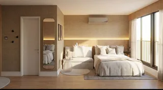 Quarto com piso de madeira e janela com cortinas brancas.