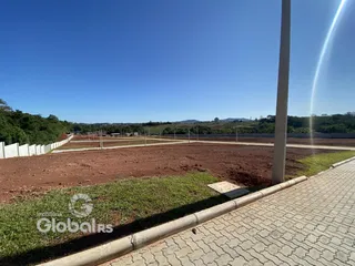 Vista externa de um terreno aberto com cerca e grama.