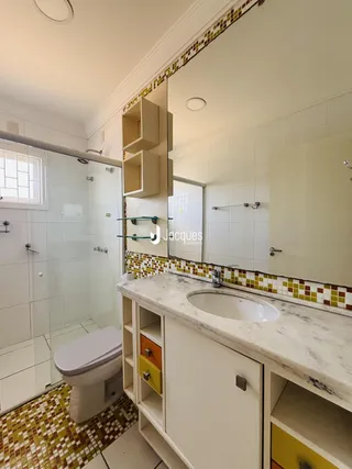 Foto de um banheiro com revestimento de azulejos e box de vidro.