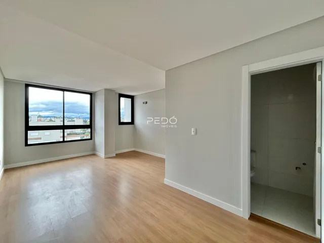 Sala de estar com piso de madeira e grande janela de vista para a paisagem.