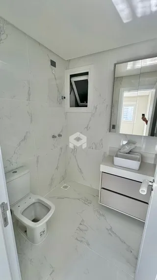 Banheiro com revestimento em mármore branco nas paredes e piso.