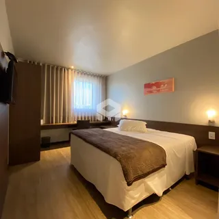 Quarto com cama e piso de madeira.