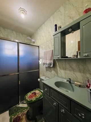Foto de um banheiro com revestimento de azulejo e bancada de madeira.