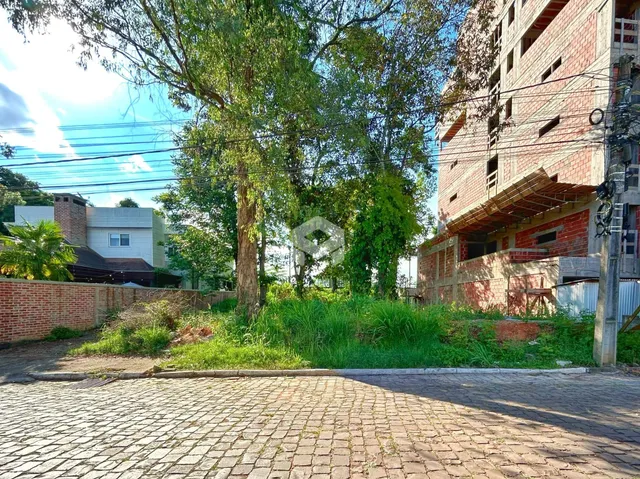 Vista externa de uma propriedade com jardim e muro de tijolos.