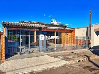 Fachada de uma residência com muro de ferro e telhado de telhas.
