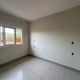 Vista interna de um cômodo com paredes brancas e piso de cerâmica.