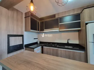 Cozinha moderna com armários de madeira e bancadas escuras.