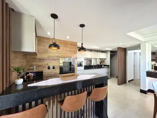 Cozinha moderna com bancada escura e detalhes em madeira.