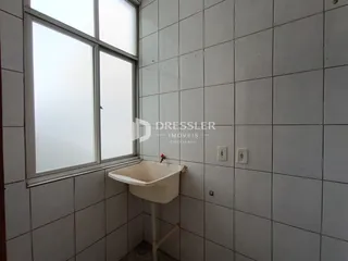 Parede de banheiro com janela e pia de cerâmica.