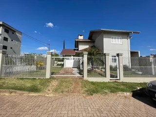 Fachada de uma residência em Lajeado, Brasil, com cerca e portão branco.