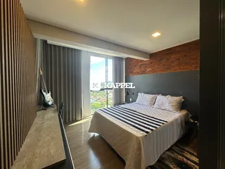 Quarto com cama grande e piso de madeira.
