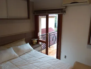 Quarto com vista para a área externa através de uma porta de vidro.