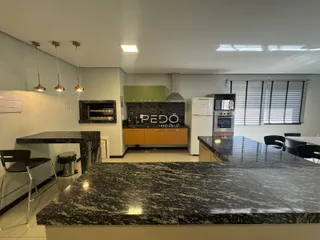 Vista de uma cozinha moderna com bancadas de granito escuro e armários em madeira.