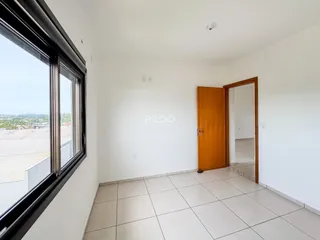 Vista interna de uma sala com piso de cerâmica e janela grande.